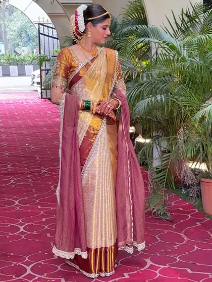 A full view of the Maharashtrian bride in a Kanjivaram saree, complete with a contrasting dupatta. This look combines the elegance of two beautiful cultures.