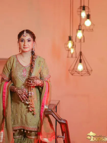 A stylish portrait of the bride on a staircase, with modern lighting contrasting the traditional setting.