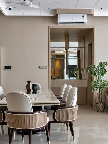 An open-plan living and dining area styled for effortless flow and connection. The neutral palette is punctuated by comfortable seating and strategic lighting, creating distinct zones for relaxing and socializing.