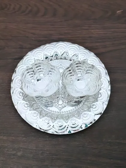 A decorative German silver plate with a mandala design, paired with two lotus-shaped kumkum holders.