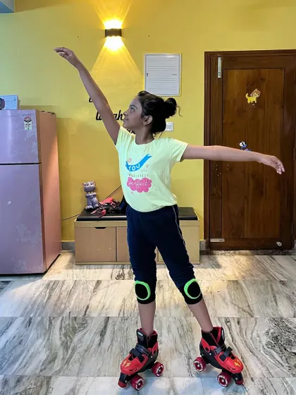 Another angle of a young student practicing her ballet arms and posture on skates.