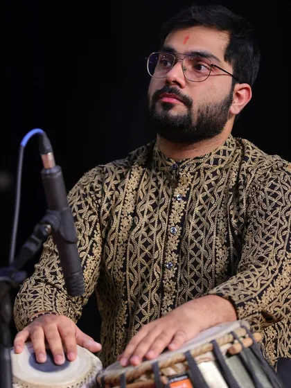 On stage, fully immersed in the performance. The intricate patterns on my kurta mirror the complex rhythms I create on the tabla, weaving a rich tapestry of sound.