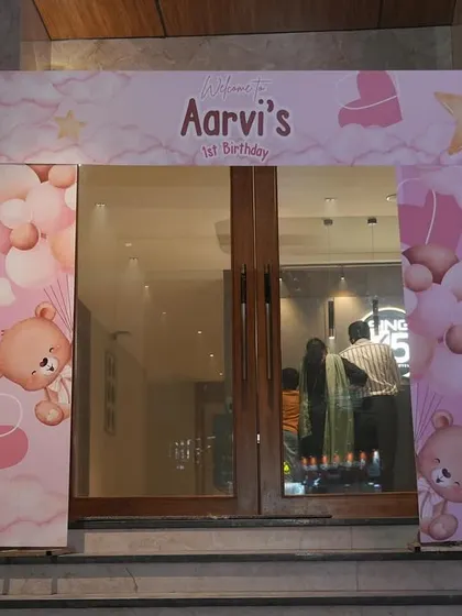 A full view of the custom-printed entrance arch for Aarvi's first birthday. The design wraps around the door frame, creating an immersive welcome for guests.