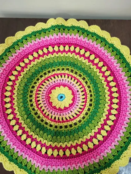 The Viola mandala laid flat, showing its perfect circular shape and the joyful color combination. It makes a wonderful doily or table centerpiece.
