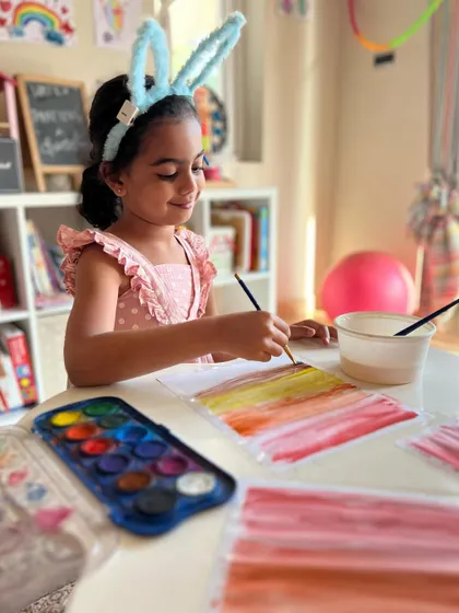 Learning to blend colors is a magical experience. This little bunny is painting a beautiful sunset, carefully layering watercolors to get that perfect evening glow.