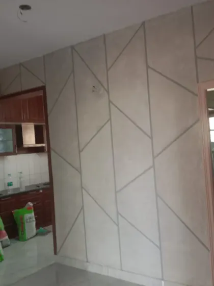 The preparation phase for a geometric wall, with masking tape applied to create the precise lines required for the design.