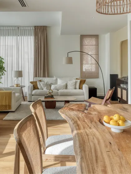 The dining area features a beautiful live-edge wooden table, reflecting the clients' Indian and African roots. The space is visually connected to the living room, encouraging a sense of togetherness.