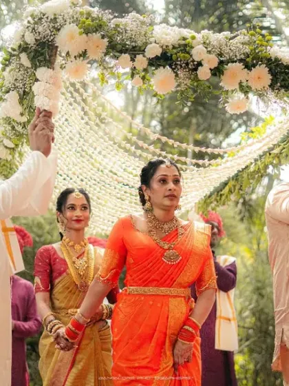 The bride's entrance under a canopy of flowers, a moment of serene beauty. I capture the grace of her walk and the support of her family.