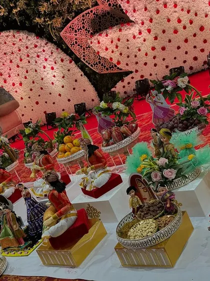 A glimpse of a full engagement theme setup. The platters are arranged on decorative stands, featuring dolls, fruits, and dry fruits, all part of a cohesive and grand display.