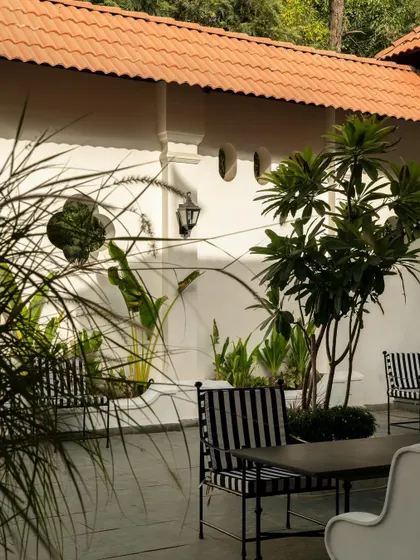Views of the courtyard at Elgin Cafe, a space designed for pause and reflection. I used white lime-washed walls, lush tropical plants, and classic lantern-style lighting to create an intimate, serene outdoor dining experience.