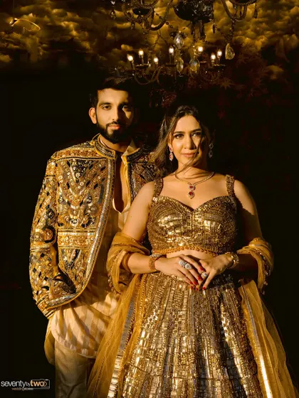 A classic, elegant portrait of the couple in their golden sangeet attire, looking regal and poised.