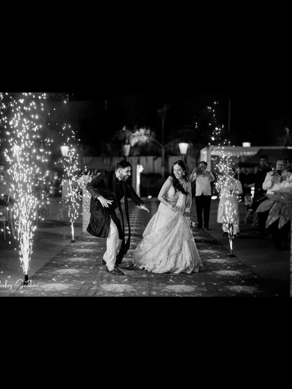 A dynamic black and white shot of the couple's energetic entrance at their Sangeet.