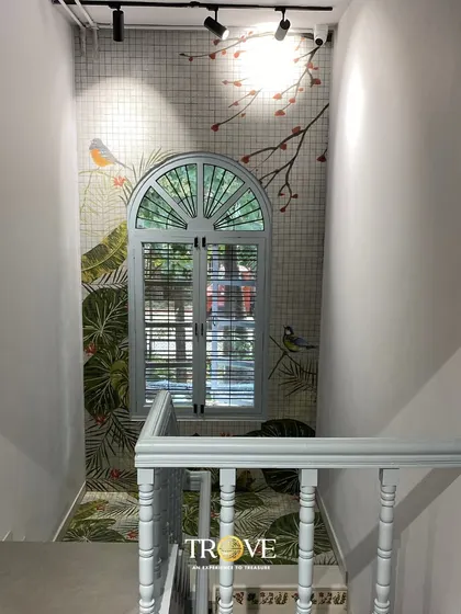 Transform a simple staircase into a beautiful feature. This landing features a custom-printed tile mural with birds and botanicals, creating a window-like illusion that adds charm and a sense of nature indoors.