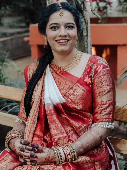 A beautiful portrait of the same smiling bride, her hands adorned with a lovely, rich mehendi stain.
