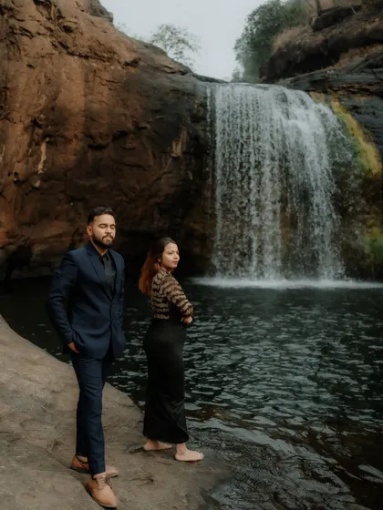 A posed, editorial-style shot of the couple at the waterfall location, showing versatility in pre-wedding photography styles.