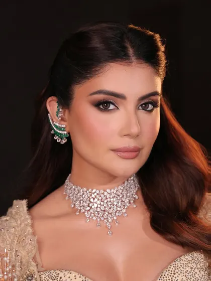 This is couture glamour for a cocktail or reception event. The look features bronzed, glowing skin and a dramatic smoky eye, paired with a nude lip to create a perfect balance of sophistication and allure.