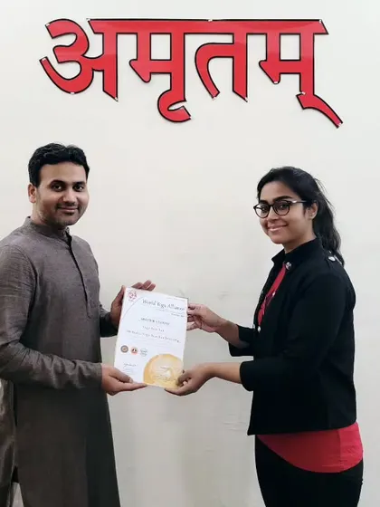 Presenting a 200-hour YTTC certificate to a student. Her bright smile reflects the joy and fulfillment found on the yoga path.