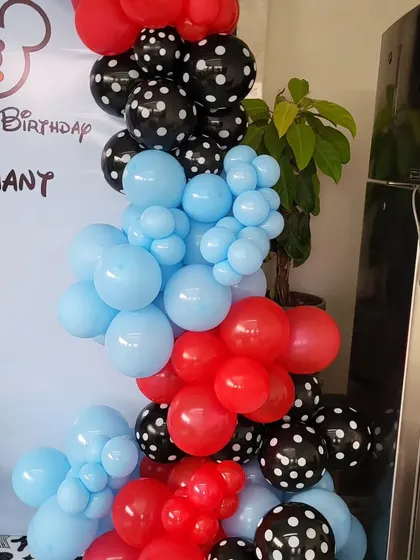 A close-up of the balloon garland for the Mickey Mouse theme, showing the mix of red, blue, and polka-dot balloons.