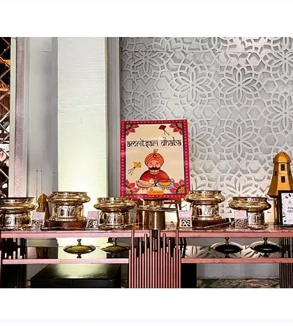 A beautifully themed buffet setup for a regional cuisine counter. The vibrant poster and traditional serving dishes create an immersive experience.