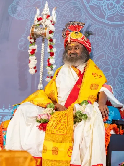 I am seated for the Maha Shivratri celebration, with the sacred trident of Shiva beside me. The entire stage is set for a night of profound spiritual experiences.