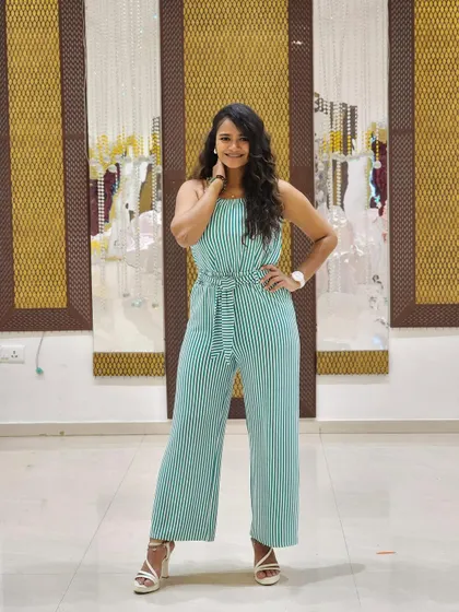 A confident pose in the striped jumpsuit. This versatile outfit is perfect for a variety of settings, from a casual day out to a semi-formal event.