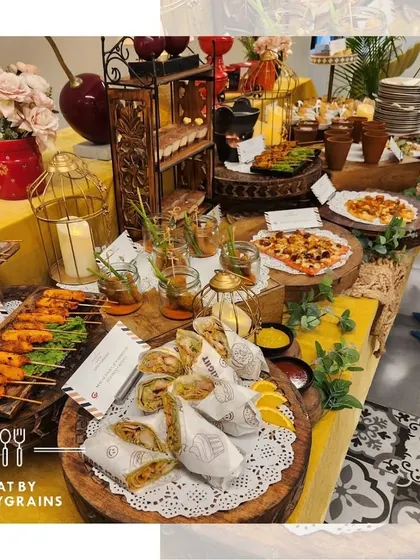 A wide view of a buffet table laden with a variety of dishes, from kebabs and wraps to pizzas and mini samosas, showcasing our diverse menu options.