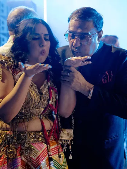A bride and her father share a playful moment, blowing kisses to the camera. It’s a sweet and fun interaction that shows the joyful side of their relationship on the wedding day.