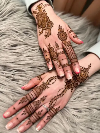 An example of a lighter, more delicate design that is perfect for wedding guests. This style features vine and floral motifs on the back of the hand, leaving parts of the skin open for a modern look.