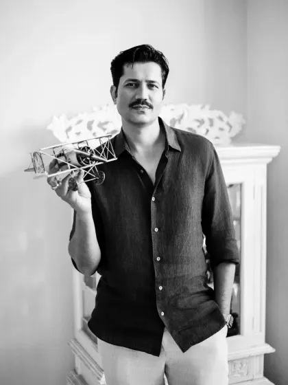 A black and white portrait of Sumeet Vyas holding a model airplane. This prop adds a layer of storytelling, suggesting themes of dreams, legacy, and the journey of fatherhood, which was the focus of the editorial.
