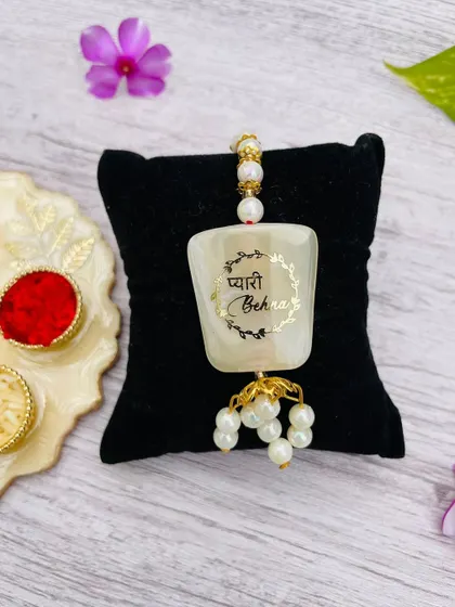 Another view of the "Pyari Behna" lumba rakhi, showing the pearl and gold-colored details.