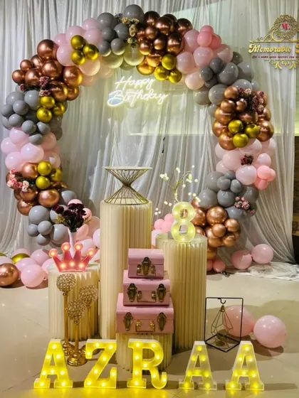 An elegant birthday setup with a mix of grey, pink, and gold balloons.