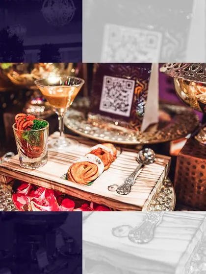 A creative presentation of appetizers on a wooden board, featuring a shot glass element and intricate garnishes, designed to be a conversation starter.