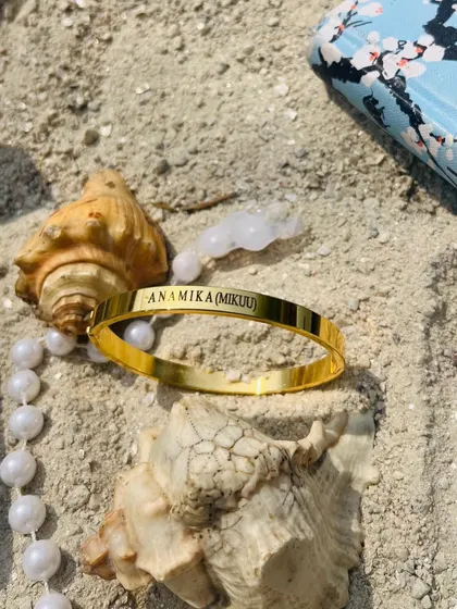 A personalized gold Kada with 'Anamika (Mikuu)' engraved, showing how you can include both a name and a special nickname.