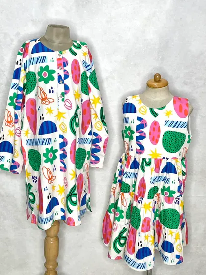 Another take on our abstract print sibling set. Here, we've created a long-sleeved tunic for an older sister and a sleeveless tiered dress for the younger one.