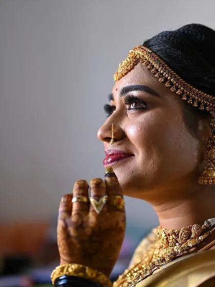 A thoughtful pose from the bride, her hand on her chin, highlighting the beautiful henna stain.