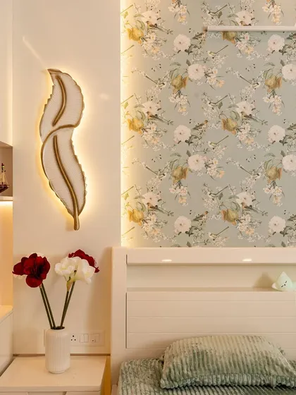 A vibrant bedroom from a 3BHK Bangalore home, featuring playful wallpapers and a feather-shaped wall light.