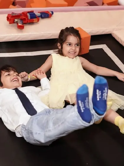 Two friends having a wonderful time playing together on the trampoline.