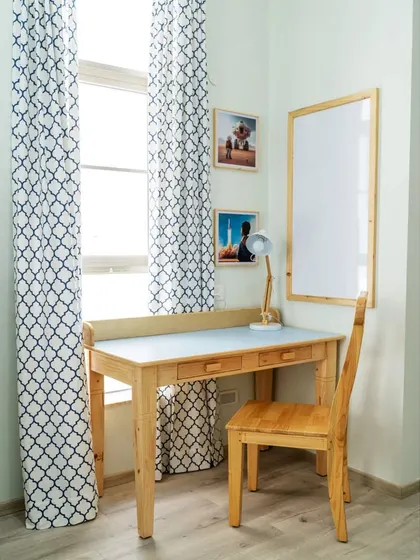 The study corner in Atharva's room, featuring a sleek pine wood desk and chair, and a large whiteboard for doodles and notes. The space is designed to be both functional and inspiring.