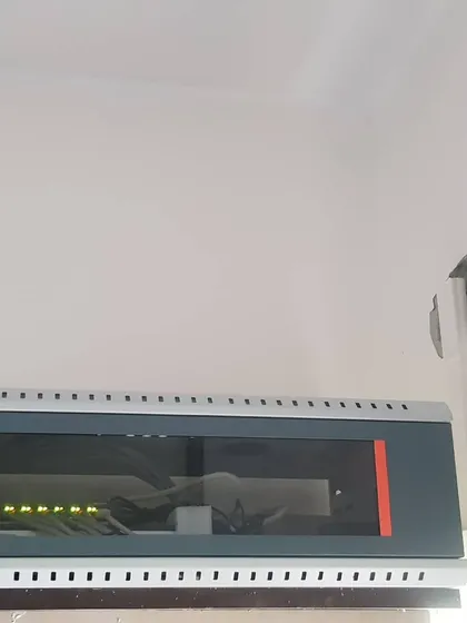 A clean installation of a network rack on a white wall, part of a home surveillance system.