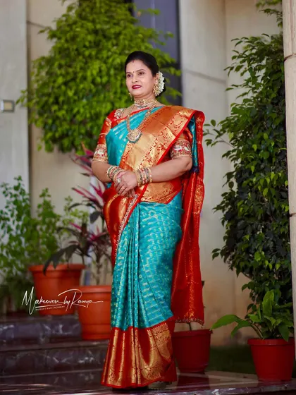A full-length portrait of Sandhya in a beautiful turquoise and red saree.