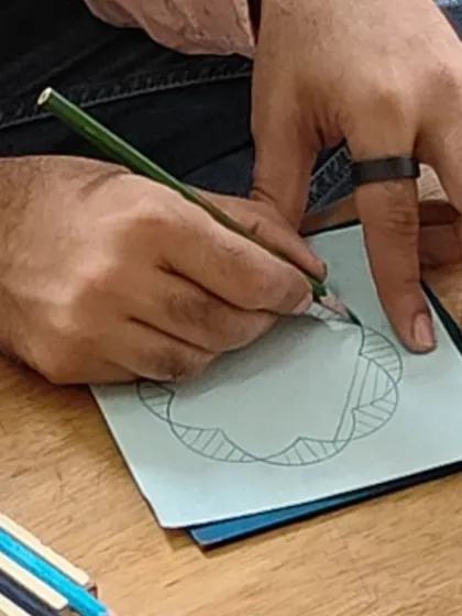 A close up of hands using the Metal Insets, a classic Montessori material for developing the fine motor skills required for handwriting. This activity builds dexterity, focus, and a light, controlled touch with the pencil.