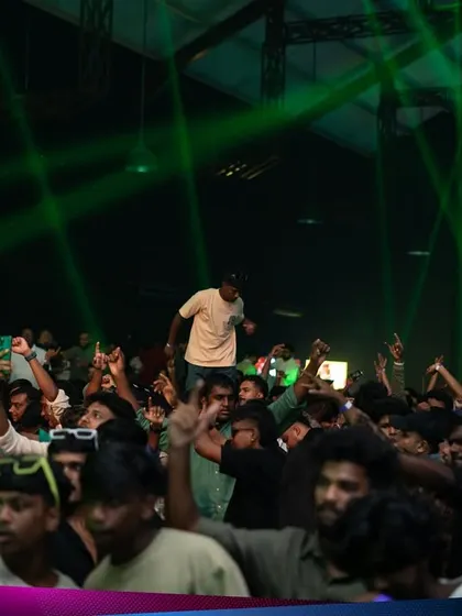 A sea of people dancing under green laser lights at the Kaavaalaa EDM festival. This is the kind of massive, high-energy scene I create.