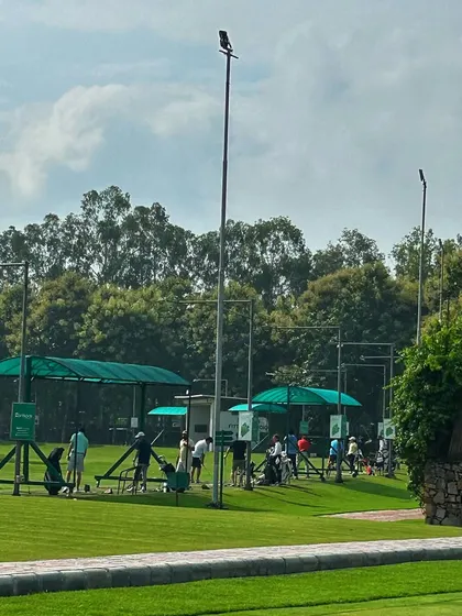 A wide shot of the driving range, showcasing the ample space and beautiful landscape that surrounds our practice facility.