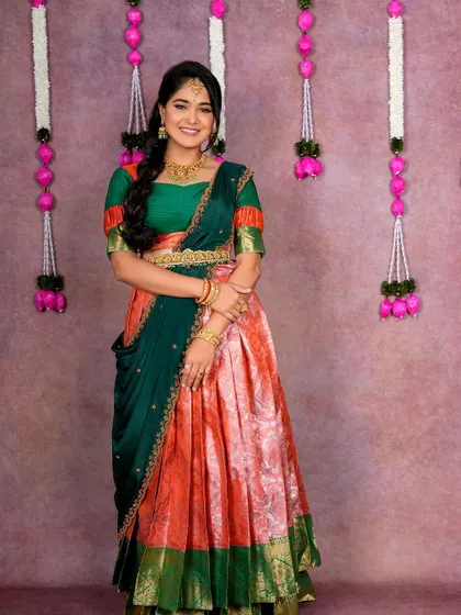 This peach and green half saree is a popular choice for its refreshing color combination, suitable for daytime events.