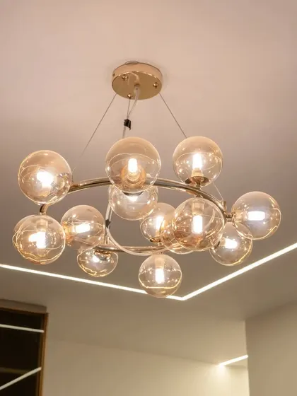 A close-up of a modern glass bubble chandelier, which adds a touch of elegance and serves as a beautiful focal point in this bio-chic bedroom.