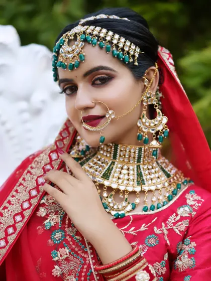 A closer look at a North Indian bridal style, focusing on the intricate jewelry, bold eyes, and rich colors of the lehenga.
