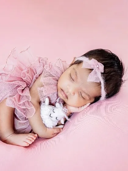 Sleeping soundly on her side, this little one is a picture of pure innocence. I gently guide newborns into comfortable poses that showcase their delicate features.