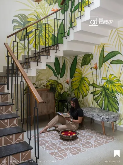 A publication feature of the staircase, highlighting the hand-painted mural and the cozy seating area underneath.