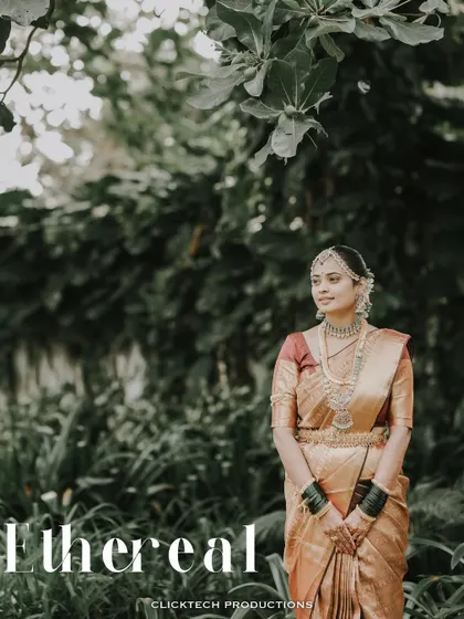 An ethereal portrait of a bride in a golden-hued saree, captured in a quiet moment amidst nature.