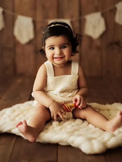 A classic sitter portrait on a soft, chunky knit blanket. This baby's happy smile and simple outfit keep the focus on her adorable personality.